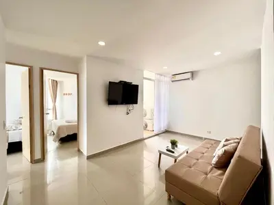 a living room with a couch and a tv on the wall at Apartamento Aqua in Cartagena de Indias