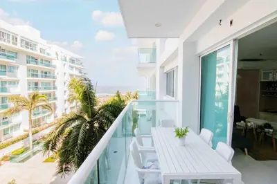 a balcony with a table and chairs and a view of the ocean at Apartamento para viajar en familia in Cartagena de Indias