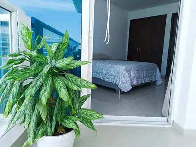 a potted plant in a room with a bedroom at Apartamento en Los Morros - Cartagena de Indias in Cartagena de Indias