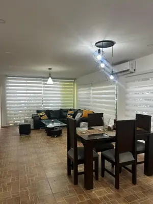 a living room with a couch and a table and chairs at Casa de campo con piscina, aire acondicionado, estacionamiento privado con BBQ in Barranquilla