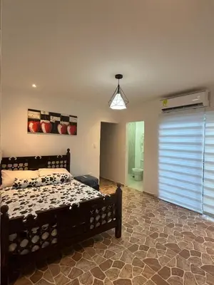 a bedroom with a bed in a room with a window at Casa de campo con piscina, aire acondicionado, estacionamiento privado con BBQ in Barranquilla