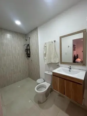 a bathroom with a toilet and a sink and a mirror at Casa de campo con piscina, aire acondicionado, estacionamiento privado con BBQ in Barranquilla