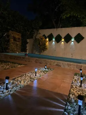 a wooden table with lights on it at night at Casa de campo con piscina, aire acondicionado, estacionamiento privado con BBQ in Barranquilla