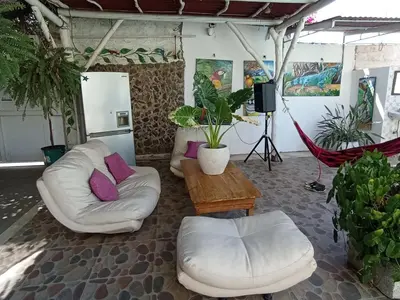 a living room with two white chairs and a table at Jardín de Díos in Santa Marta