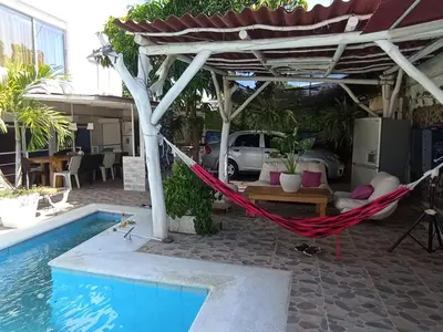 a hammock under a pergola next to a pool at Jardín de Díos in Santa Marta
