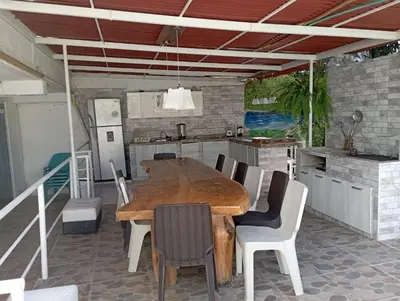 a kitchen with a large wooden table and chairs at Jardín de Díos in Santa Marta
