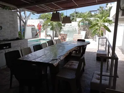 a dining room with a large wooden table and chairs at Jardín de Díos in Santa Marta