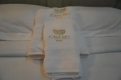 two white towels sitting on top of a bed at Casa Rio in Mangue