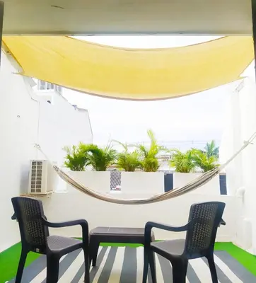 a room with two chairs and a table and a hammock at Apto Centro Historico Quero in Cartagena de Indias