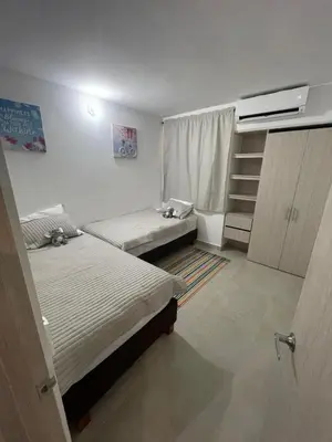 a bedroom with two beds and a window and shelves at Apartamento Cartagena Serena del Mar - Capriella in Manzanillo del Mar