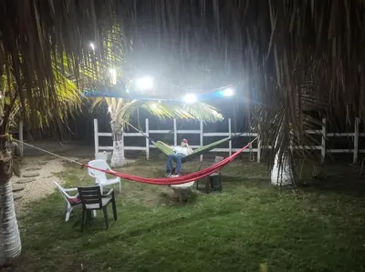 a man sitting on a hammock in a yard at night at la casablanca moñitos in Moñitos