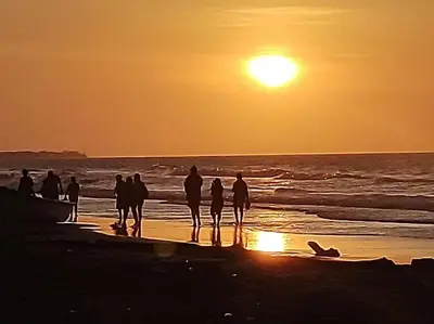 a group of people standing on the beach at sunset at Habitación 6 personas in Moñitos