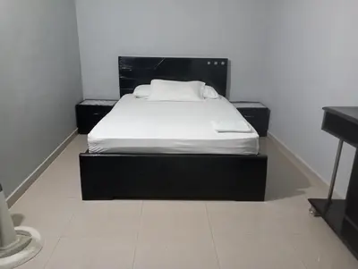 a bed in a room with a black bed frame at Habitación con wi-fi, Ac, cocina en Cartagena in Cartagena de Indias