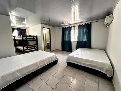 a bedroom with two beds and a room with a desk at Casa Naty Crespo in Cartagena de Indias