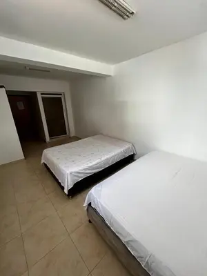 two beds in a room with white walls at Casa Naty Crespo in Cartagena de Indias