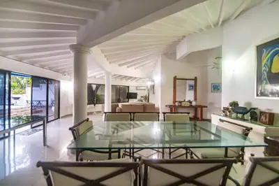 a dining room with a glass table and chairs at Casa de playa Vistamare in Santa Marta