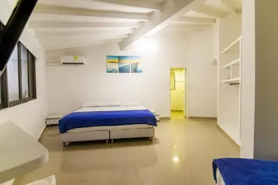 a bedroom with a bed in a white room at Casa de playa Vistamare in Santa Marta