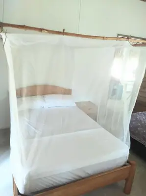 a bed with a mosquito net on top of it at Habitación 4 personas in Moñitos