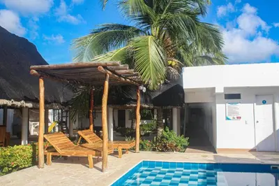 a resort with two chairs and a umbrella and a pool at Chalet Ledymar in Cartagena de Indias