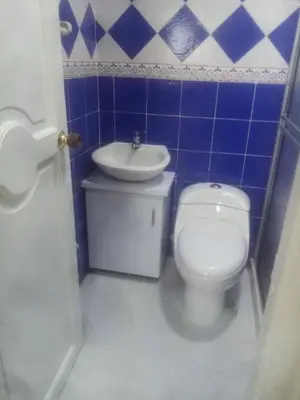 a blue tiled bathroom with a toilet and a sink at Chalet Ledymar in Cartagena de Indias