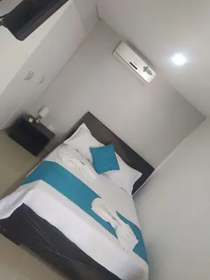 a bedroom with a bed with blue and white sheets at Chalet Ledymar in Cartagena de Indias