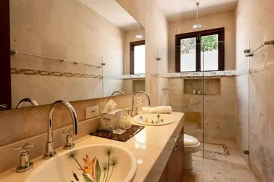 a bathroom with two sinks and a toilet and a mirror at Luxury Apartment Private Pool & Rooftop Jacuzzi in Cartagena de Indias