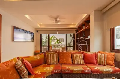 an orange couch with pillows in a living room at Luxury Apartment Private Pool & Rooftop Jacuzzi in Cartagena de Indias