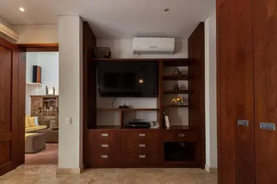 a living room with a entertainment center with a flat screen tv at Luxury Apartment Private Pool & Rooftop Jacuzzi in Cartagena de Indias