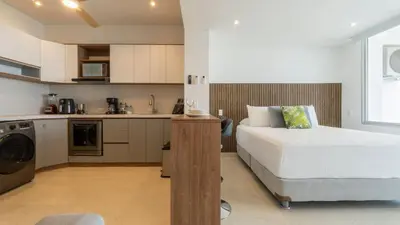 a small bedroom with a bed and a kitchen at Suite con daybed piso 16 y balcón panorámico CB1638 in Cartagena de Indias
