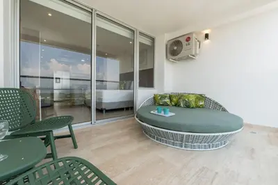 a room with a couch and a table and a bed at Suite con daybed piso 16 y balcón panorámico CB1638 in Cartagena de Indias