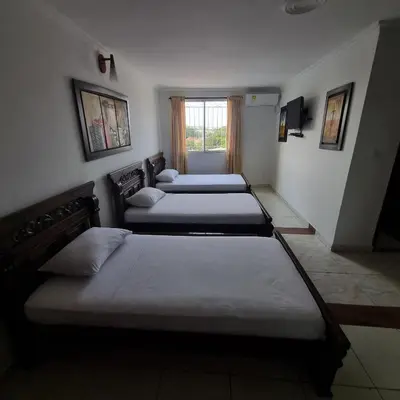 a group of four beds in a room at Hotel Cartagena Comfort in Cartagena de Indias