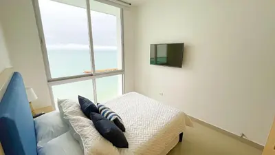 a bedroom with a bed with pillows and a window at Magico Apartamento Frente al Mar 4 Habitaciones BM83 in Coveñas