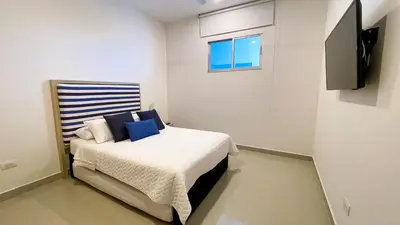 a bedroom with a bed and a television on a wall at Magico Apartamento Frente al Mar 4 Habitaciones BM83 in Coveñas