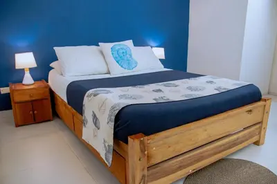 a bedroom with a wooden bed with a blue wall at Loft with view 7 rooms in Cartagena de Indias