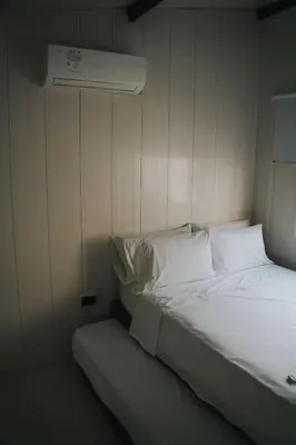 a bed with white sheets and pillows in a room at Almare Beach House Cartagena in Cartagena de Indias