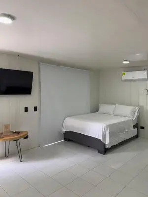 a bedroom with a bed and a flat screen tv at Almare Beach House Cartagena in Cartagena de Indias