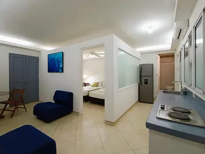 a kitchen and living room with a sink and a room with a bed at Acogedores Apartaestudios en Getsemaní in Cartagena de Indias