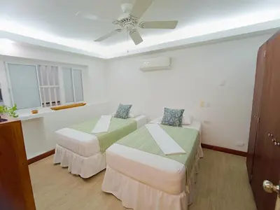 a room with two beds and a ceiling fan at Acogedores Apartaestudios en Getsemaní in Cartagena de Indias