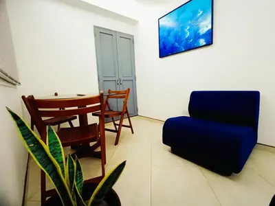 a living room with a blue chair and a table at Acogedores Apartaestudios en Getsemaní in Cartagena de Indias