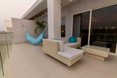 a living room with a hammock and a couch and chairs at Condominio frente al mar con acceso directo a la playa Morros IO in Cartagena de Indias