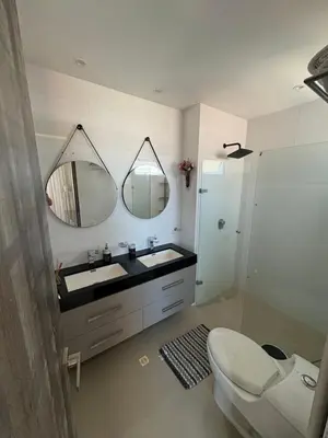 a bathroom with a toilet and a sink and a mirror at Apto moderno frente CC Buenavista, lujo y vistas in Barranquilla