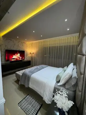 a bedroom with a large bed and a fireplace at Apto moderno frente CC Buenavista, lujo y vistas in Barranquilla