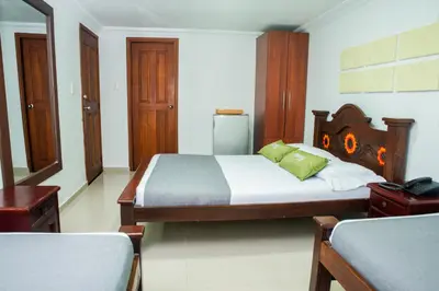 a bedroom with a large bed with a wooden headboard at Ayenda 1315 Candiac in Barranquilla