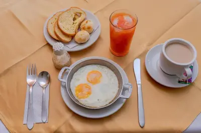 a table with eggs and toast and a cup of coffee at Ayenda 1315 Candiac in Barranquilla