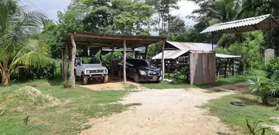 two trucks parked under a shed with a car at Casa Finca la Parcela in San Onofre