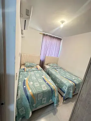 a bedroom with two beds and a window at MY lOVE BARRANQUILLA 1 in Barranquilla