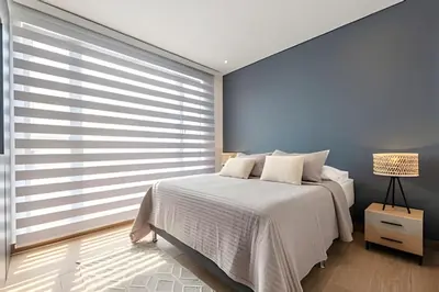 a bedroom with a white bed and a large window at NEW Panoramic view, Infinite Pool/Historic Center in Cartagena de Indias
