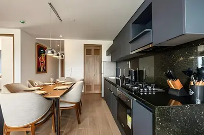 a kitchen with a wooden table and a dining room at NEW Panoramic view, Infinite Pool/Historic Center in Cartagena de Indias