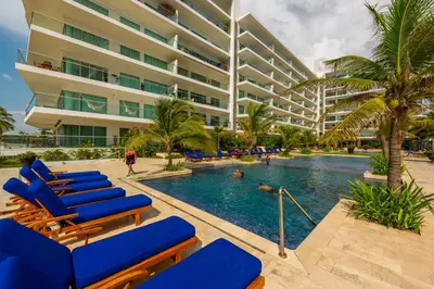 a swimming pool with blue lounge chairs and a building at Morros Epic 216 in Cartagena de Indias
