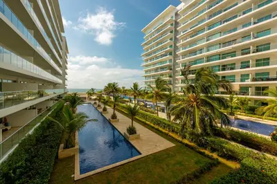 an external view of a building with a pool and palm trees at Morros Epic 216 in Cartagena de Indias